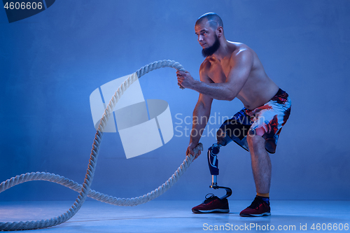 Image of Athlete disabled amputee isolated on blue studio background