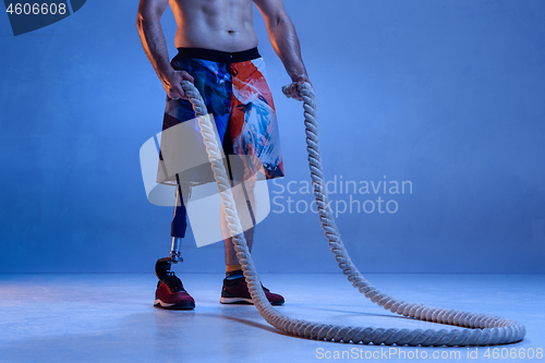 Image of Athlete disabled amputee isolated on blue studio background