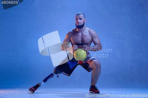 Image of Athlete disabled amputee isolated on blue studio background