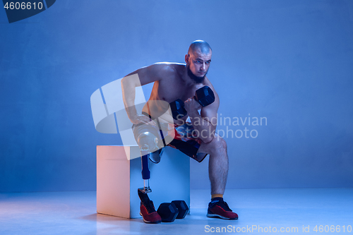 Image of Athlete disabled amputee isolated on blue studio background