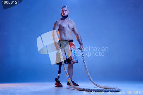 Image of Athlete disabled amputee isolated on blue studio background