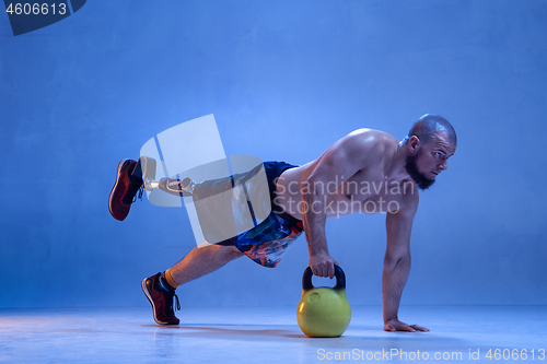 Image of Athlete disabled amputee isolated on blue studio background