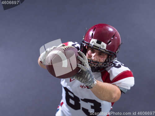 Image of american football player showing football to camera