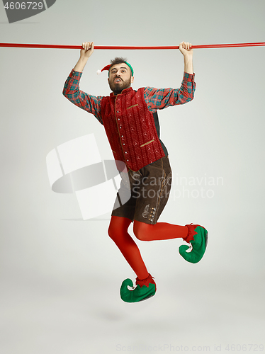 Image of friendly man dressed like a funny gnome posing on an isolated gray background