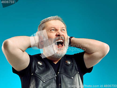 Image of Smiling middle-aged man happy expression posing in front of a blue background with copy space