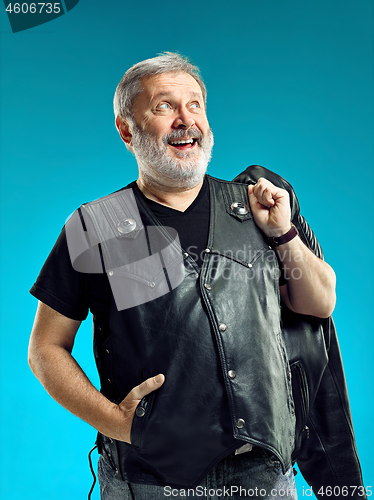Image of Smiling middle-aged man happy expression posing in front of a blue background with copy space