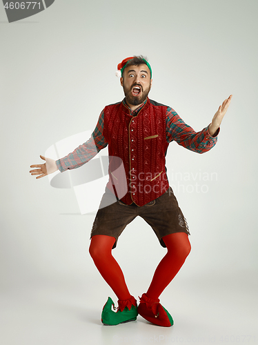 Image of friendly man dressed like a funny gnome posing on an isolated gray background