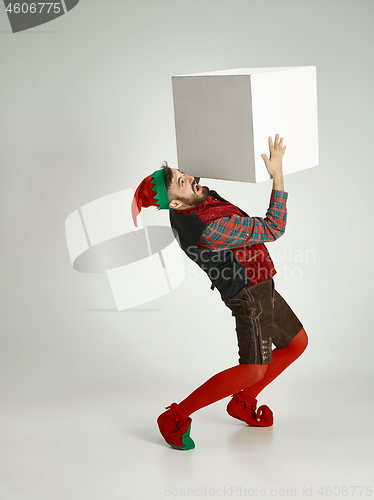 Image of friendly man dressed like a funny gnome posing on an isolated gray background