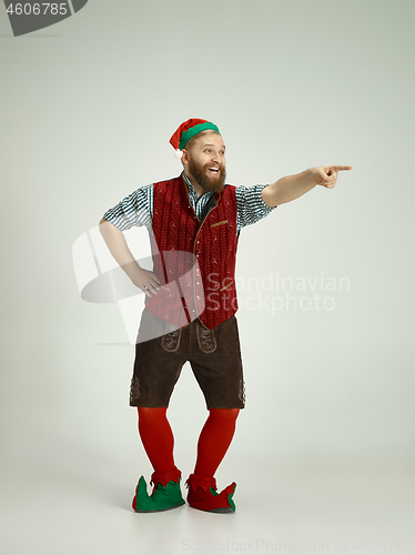 Image of friendly man dressed like a funny gnome posing on an isolated gray background