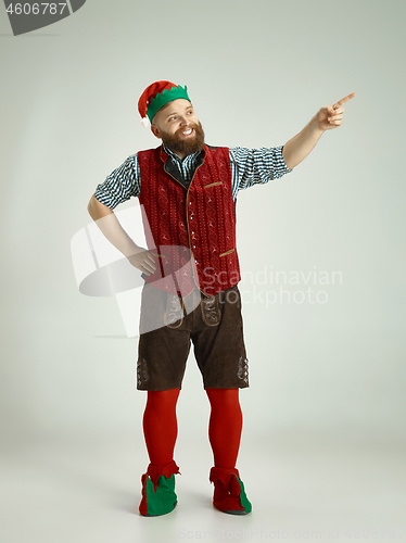 Image of friendly man dressed like a funny gnome posing on an isolated gray background