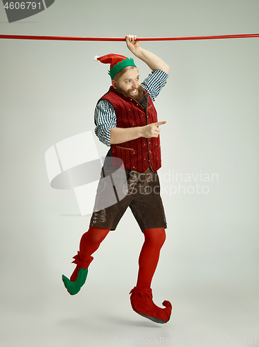 Image of friendly man dressed like a funny gnome posing on an isolated gray background