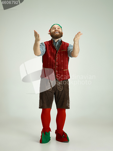 Image of friendly man dressed like a funny gnome posing on an isolated gray background
