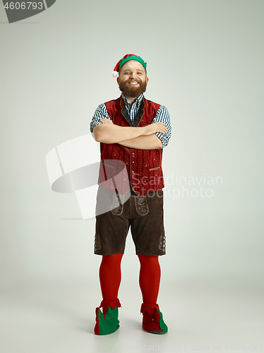 Image of friendly man dressed like a funny gnome posing on an isolated gray background