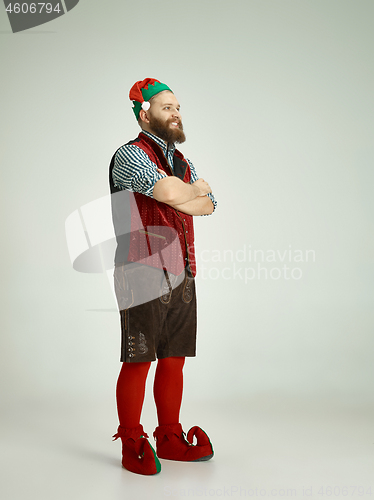 Image of friendly man dressed like a funny gnome posing on an isolated gray background