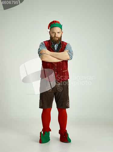 Image of friendly man dressed like a funny gnome posing on an isolated gray background