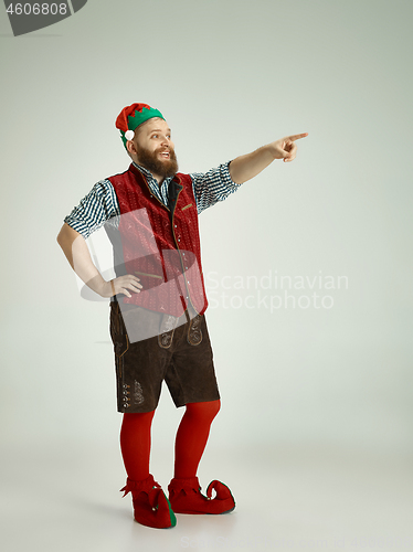 Image of friendly man dressed like a funny gnome posing on an isolated gray background