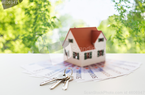 Image of close up of home model, money and house keys