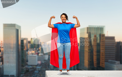 Image of happy african american woman in superhero red cape