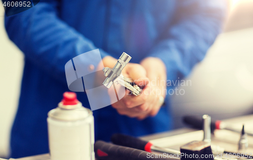 Image of mechanic man with wrench repairing car at workshop