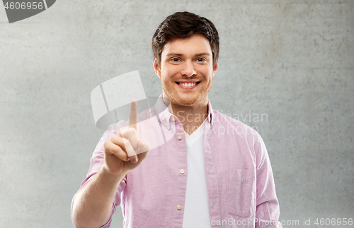 Image of man showing one finger over gray concrete wall