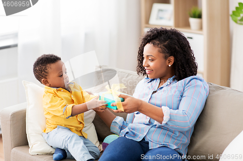 Image of happy mother giving present to her baby at home