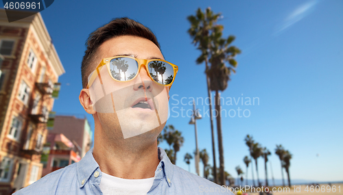 Image of surprised man in sunglasses over venice beach