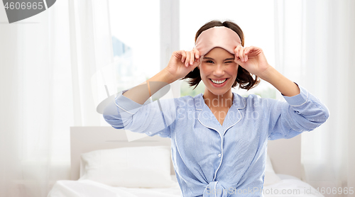 Image of happy young woman in pajama and eye sleeping mask