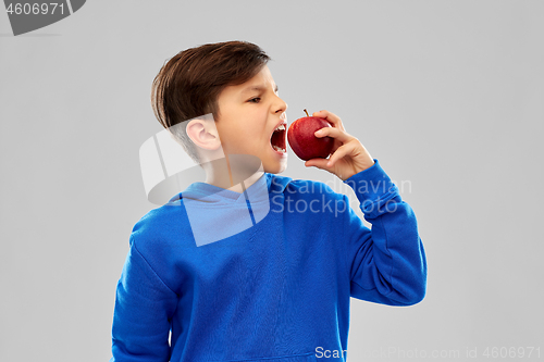 Image of angry boy in blue hoodie with red apple