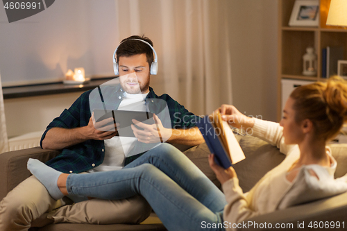 Image of couple with tablet computer and book at home