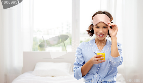 Image of woman in pajama and sleeping mask with juice