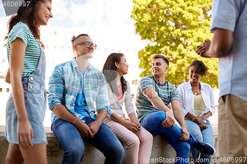 Image of happy international friends talking in city