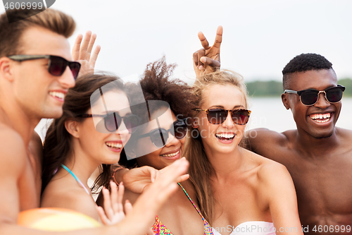 Image of happy friends in sunglasses on summer beach