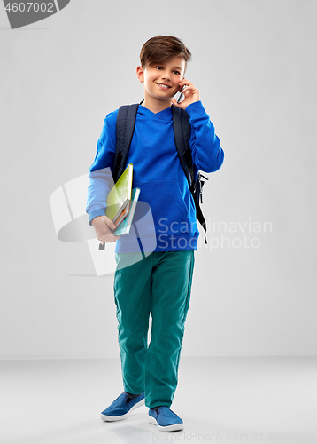 Image of student boy with school bag calling on smartphone