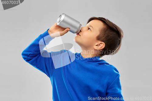 Image of boy in blue hoodie drinking soda from tin can