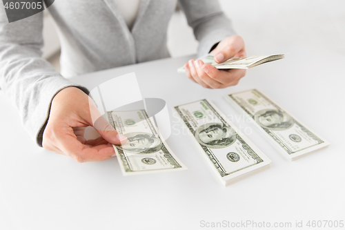 Image of close up of woman hands counting us dollar money