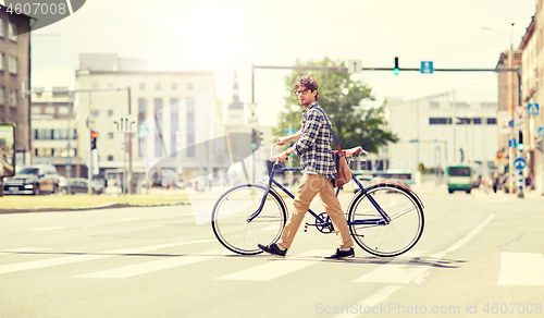 Image of young man with fixed gear bicycle on crosswalk