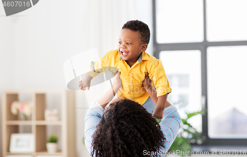 Image of happy african american mother with baby at home