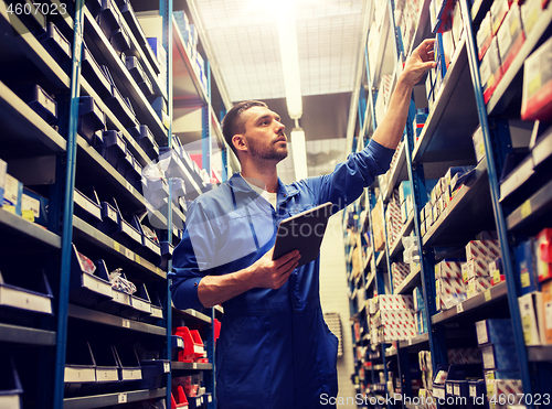 Image of auto mechanic or smith with tablet pc at workshop