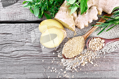 Image of Ginger ground and flakes in spoons with root on board top