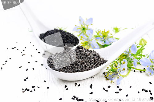 Image of Flour and seeds of kalingi in spoons on light board