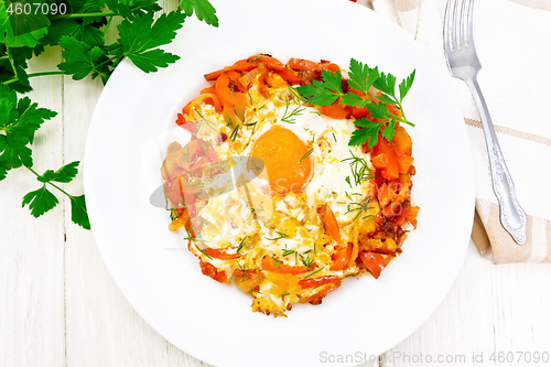 Image of Scrambled eggs with vegetables in plate on board top