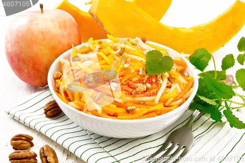 Image of Salad of pumpkin and apple in bowl on light board