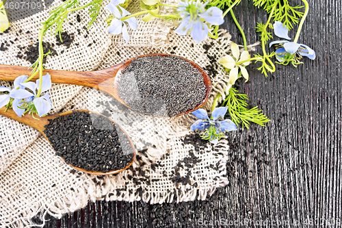 Image of Flour and seeds of kalingi in spoons on old board top