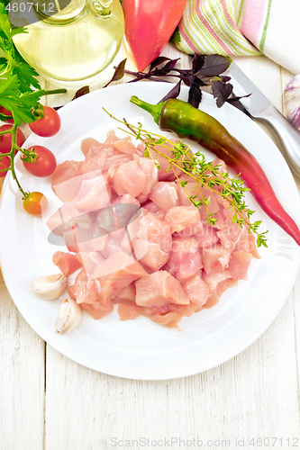 Image of Chicken breast raw sliced in plate with vegetables on board top