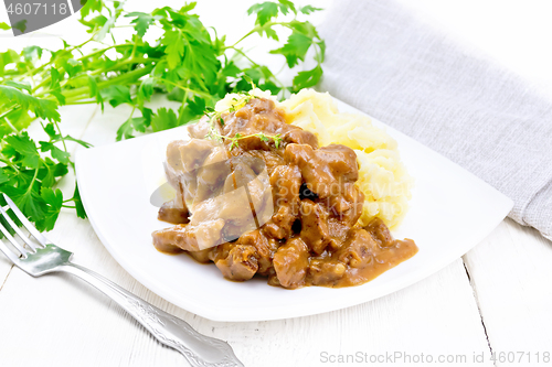 Image of Goulash of beef with mashed potatoes in plate on wooden board