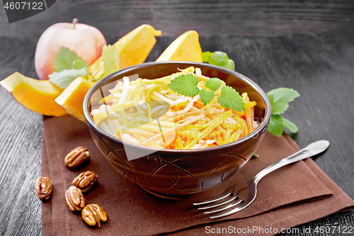 Image of Salad of pumpkin and apple in bowl on dark board