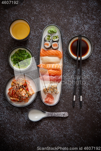 Image of Asian food assortment. Various sushi rolls placed on ceramic plates