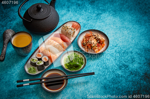 Image of Asian food assortment. Various sushi rolls placed on ceramic plates