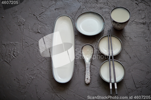 Image of Set of empty ceramic dishes for sushi and rolls on a black stone table