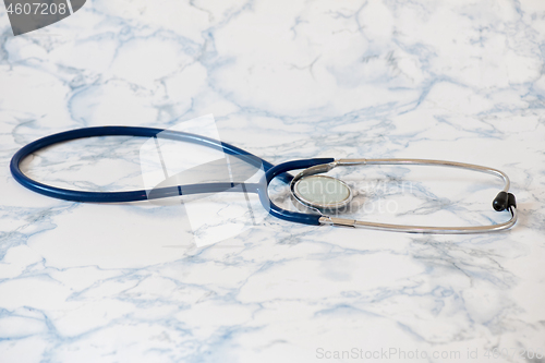 Image of Medical stethoscope or phonendoscope over light blue background Tablet in the fingers of hand